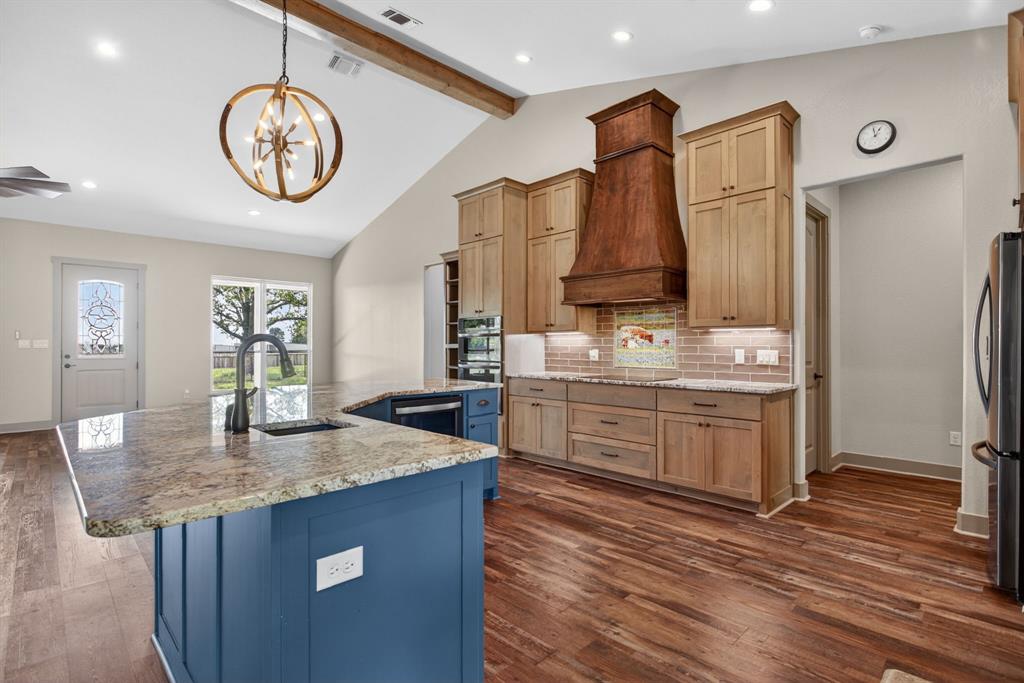 990 Doss Road Millsap, TX 76066 - Photo 16 of 39 a kitchen with stainless steel appliances granite countertop a sink a stove and a wooden floors