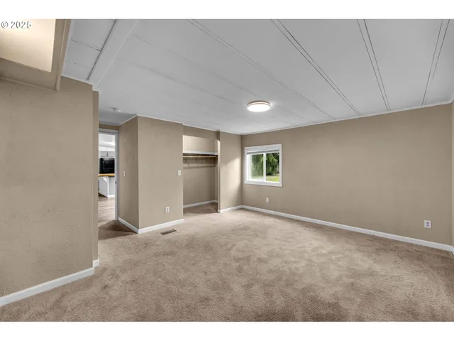 a view of empty room with a kitchen