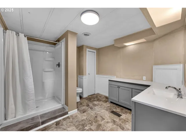 a bathroom with a sink mirror and a shower