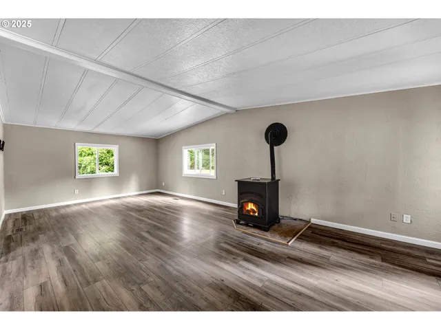 a view of empty room with fireplace and window