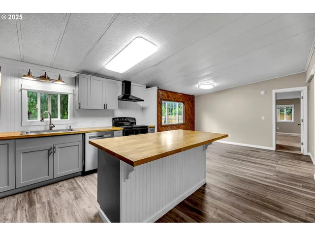 a kitchen with granite countertop a sink cabinets and wooden floor