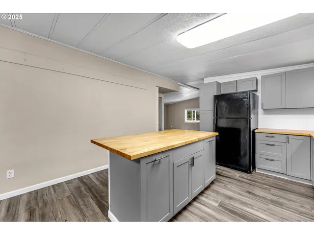 a kitchen with a wooden floor and cabinets