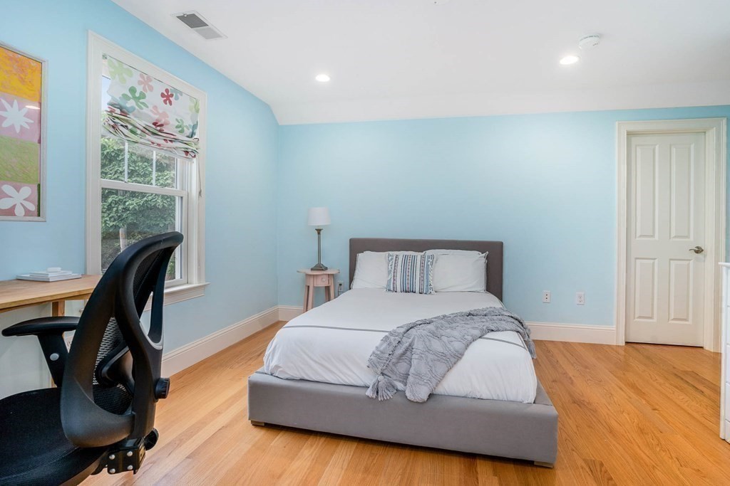 19 Lyon Road Brookline, MA 02467 - Photo 24 of 41 a bedroom with a bed a desk and chair with wooden floor
