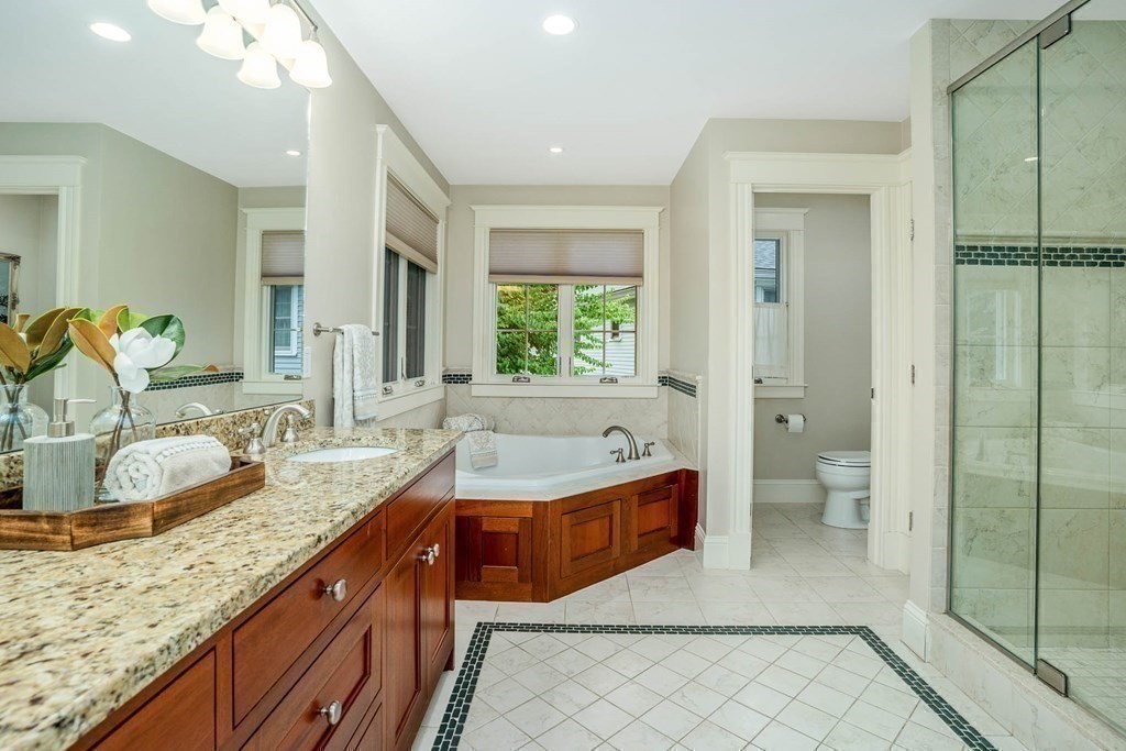 19 Lyon Road Brookline, MA 02467 - Photo 32 of 41 a bathroom with a granite countertop double vanity sink a mirror and a bathtub