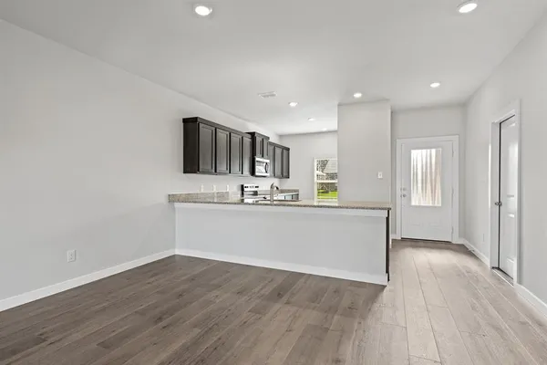 a view of kitchen with wooden floor and electronic appliances