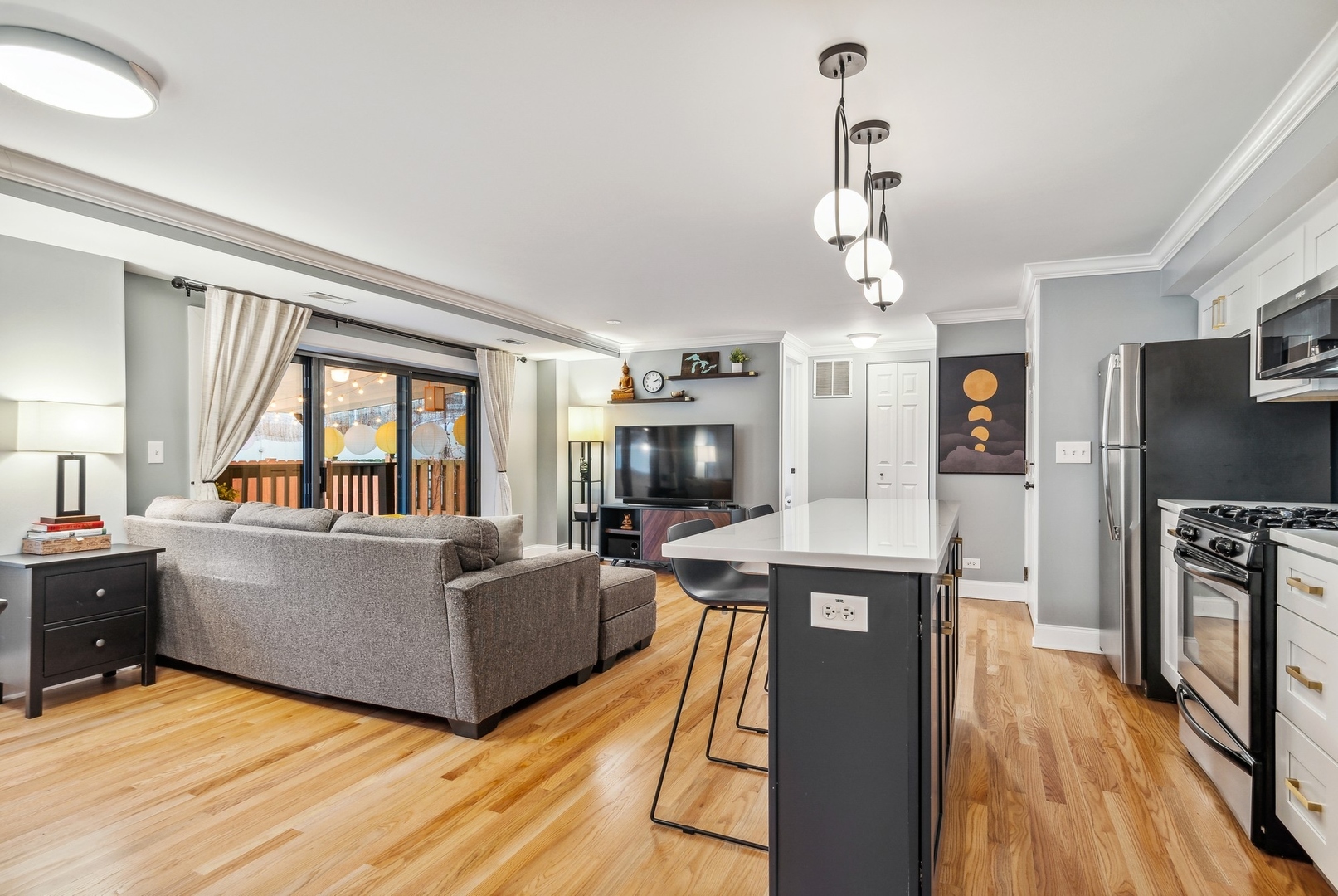 4144 North Sheridan Road, Unit 101 Chicago, IL 60613 - Photo 3 of 15 a living room with furniture a flat screen tv and a floor to ceiling window