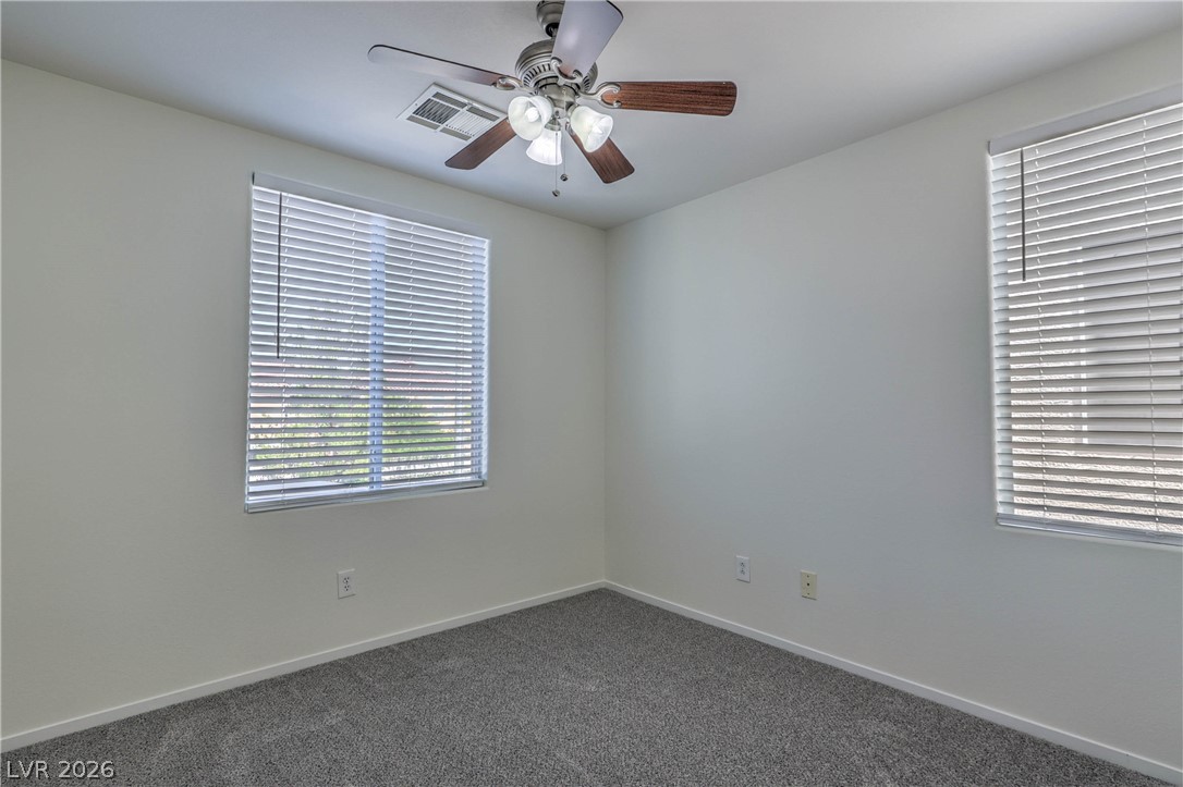 10939 Paradise Road Henderson, NV 89052 - Photo 27 of 36 A well-lit bedroom offering a neutral palette and plush carpeting, perfect for peaceful repose.
