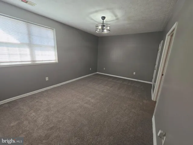 a view of an empty room with a chandelier