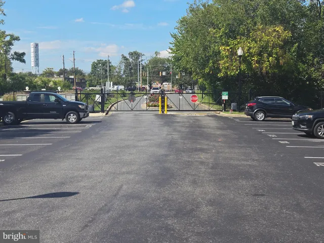 a view of a street with a fountain plants and large trees