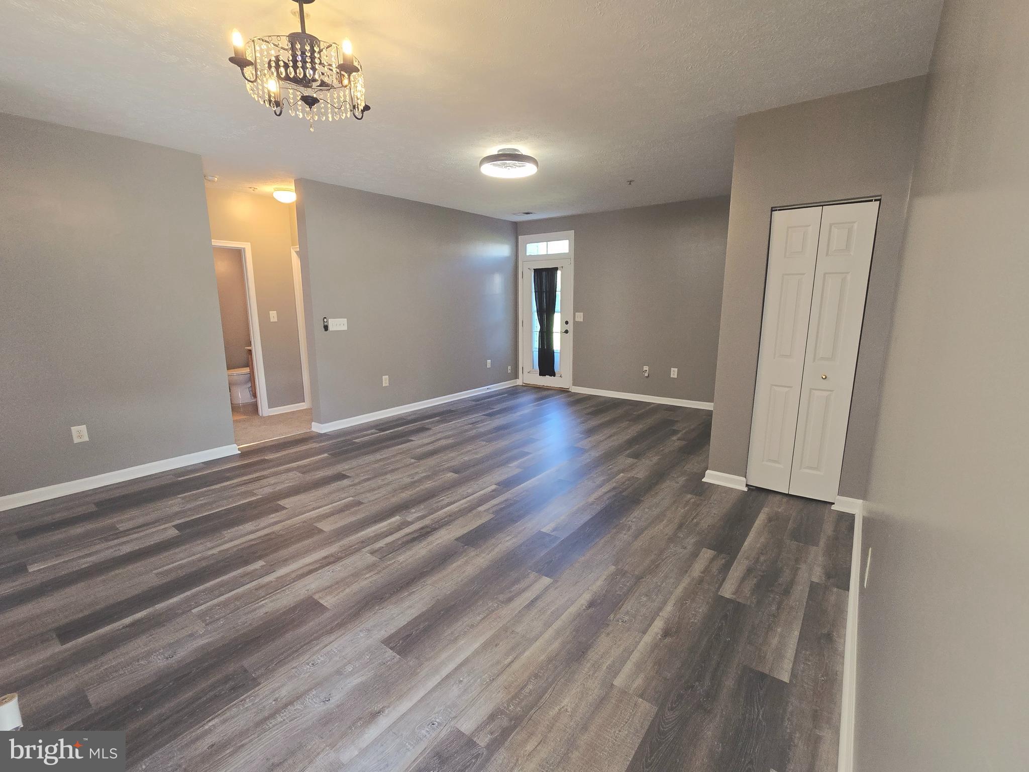 118 Heather Stone Way, Unit 80 Glen Burnie, MD 21061 - Photo 8 of 27 a view of an empty room with wooden floor and chandelier