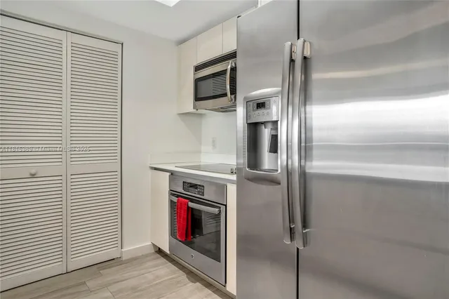a kitchen with stainless steel appliances cabinets and a wooden floor