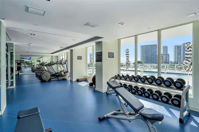a living room with furniture hard wood floor and gym equipment