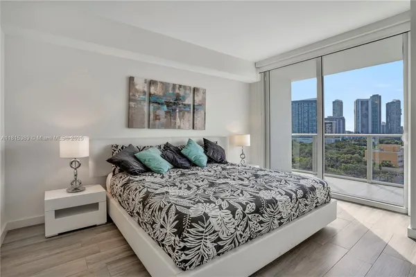 a bedroom with a large bed and a wooden floor