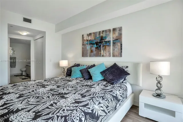 a bedroom with a large bed and a chandelier