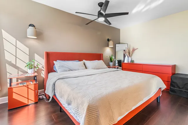 a bedroom with bed and wooden floor