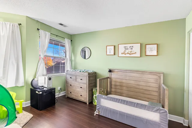 a room with a baby bed baby crib and a window