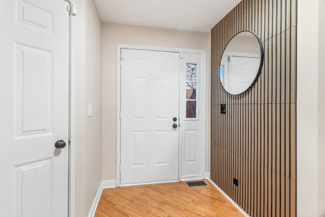 a view of a bathroom with wooden floor mirror and window