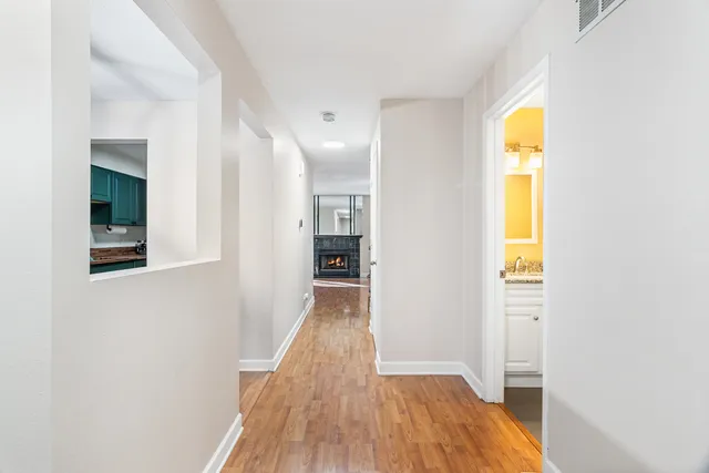 a view of a hallway with wooden floor and a window