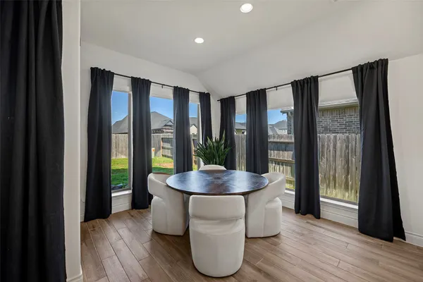 a dining room with furniture and wooden floor