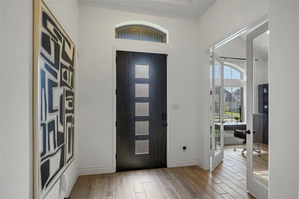 a view of a hallway with wooden floor and a living room