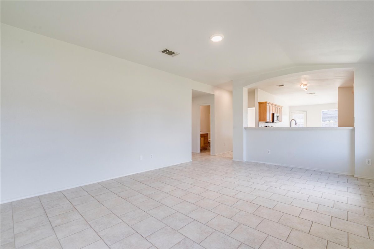 100 Easy Street Hutto, TX 78634 - Photo 5 of 36 An inviting open-concept space features resilient tile flooring and a view into the kitchen area.
