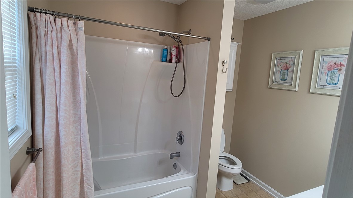 325 McAdams School Road Honea Path, SC 29654 - Photo 15 of 22 A well-appointed bathroom with a classic tub and shower combination, complemented by a window for natural illumination.
