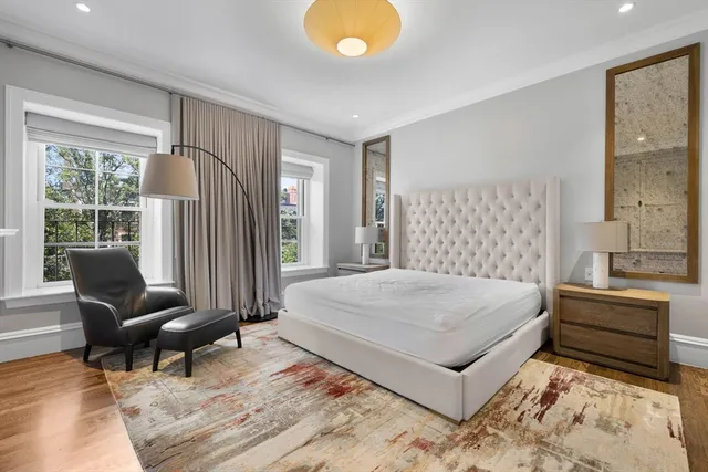 a bedroom with a bed a lamp and a large window