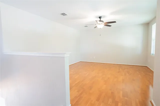 a view of empty room with a fan and a window