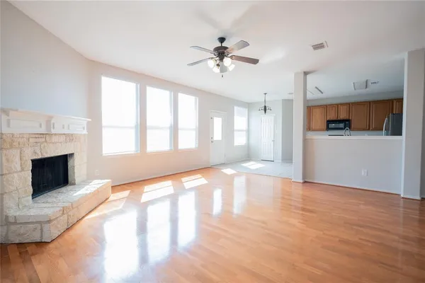 a view of an empty room with a window and fireplace