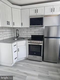 a kitchen with white cabinets stainless steel appliances and a sink
