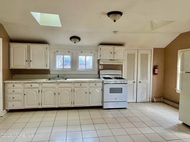 a kitchen with granite countertop a stove top oven sink and cabinets