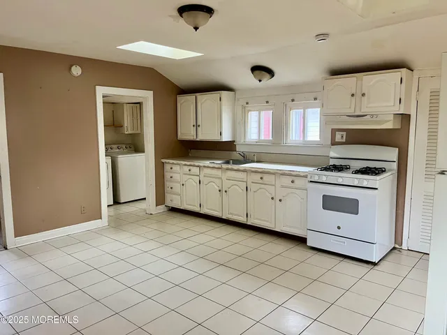 a kitchen with stainless steel appliances granite countertop a sink a stove and a refrigerator