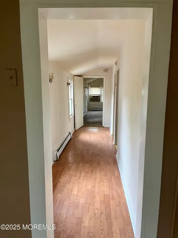 a view of a hallway with wooden floor