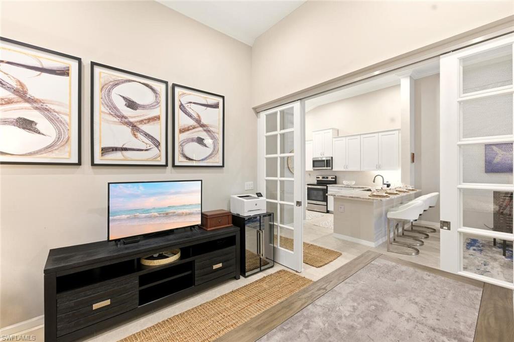9365 Pocida Court, Unit 202 Naples, FL 34119 - Photo 9 of 40 a living room with couch and a flat screen tv