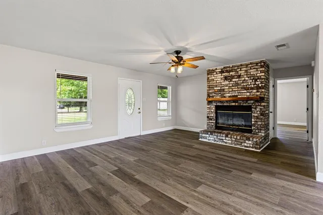 a view of an empty room with a fireplace and a window