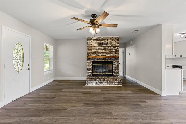 a view of an empty room with a fireplace and a window