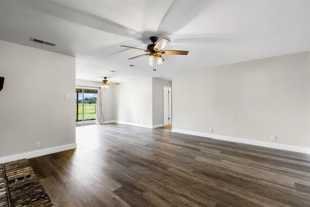 a view of a kitchen with a stove cabinets wooden floor and a ceiling fan
