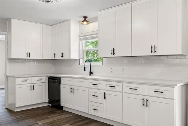 a kitchen with granite countertop a refrigerator and a sink