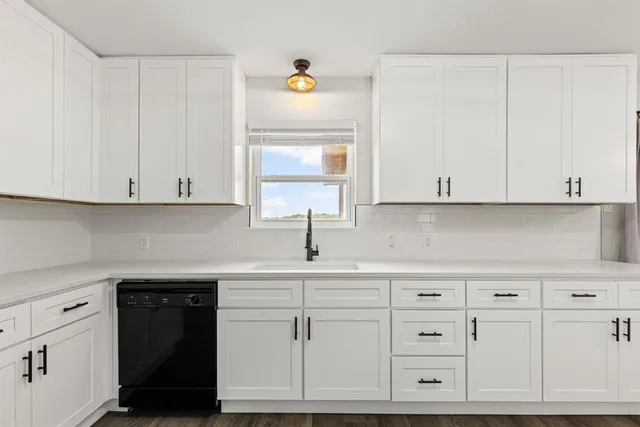 a kitchen with white cabinets and a stove