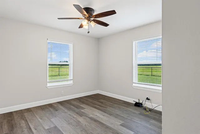 an empty room with a window and a ceiling fan
