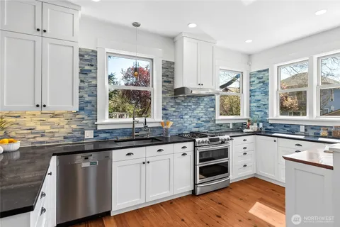 a kitchen with stainless steel appliances granite countertop a stove and cabinets