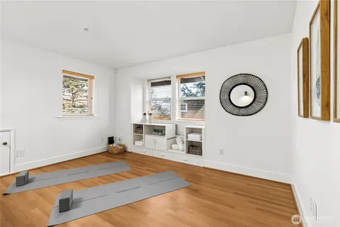 a living room with stainless steel appliances wooden floor and a window