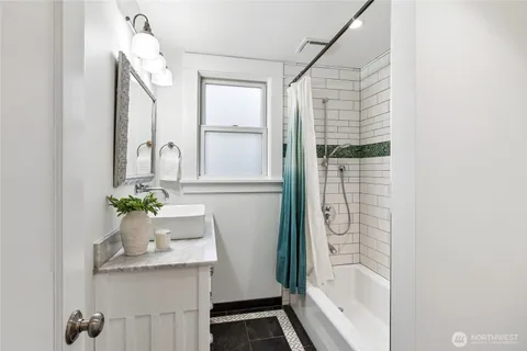 a bathroom with a granite countertop sink a mirror and shower