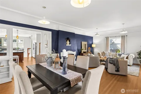a dining room with furniture a wooden floor and a large window