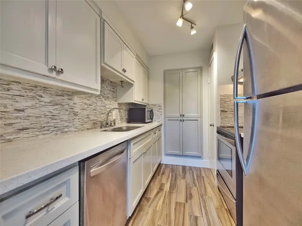 a kitchen with a sink a refrigerator and cabinets