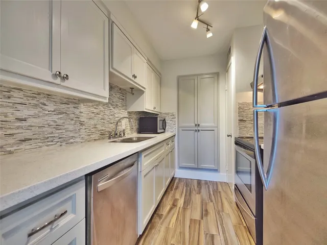 a kitchen with a sink a refrigerator and cabinets