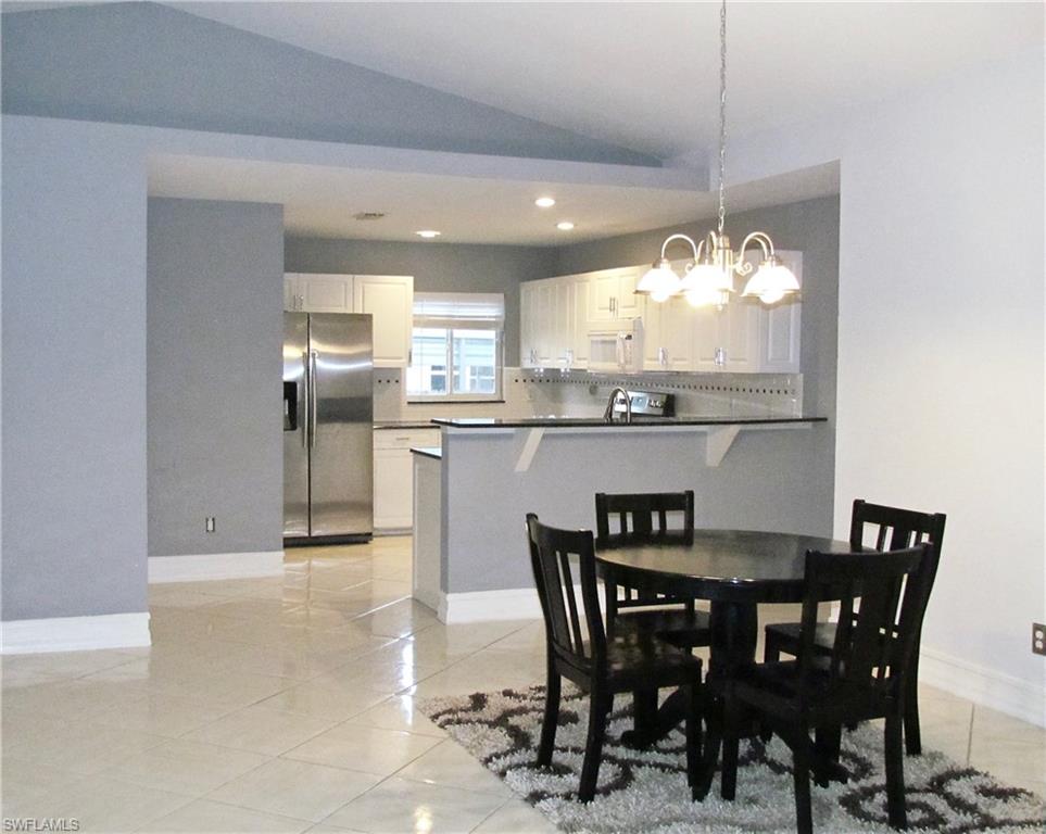 9124 Morris Road Fort Myers, FL 33967 - Photo 12 of 29 a dining room filled chandelier and kitchen view
