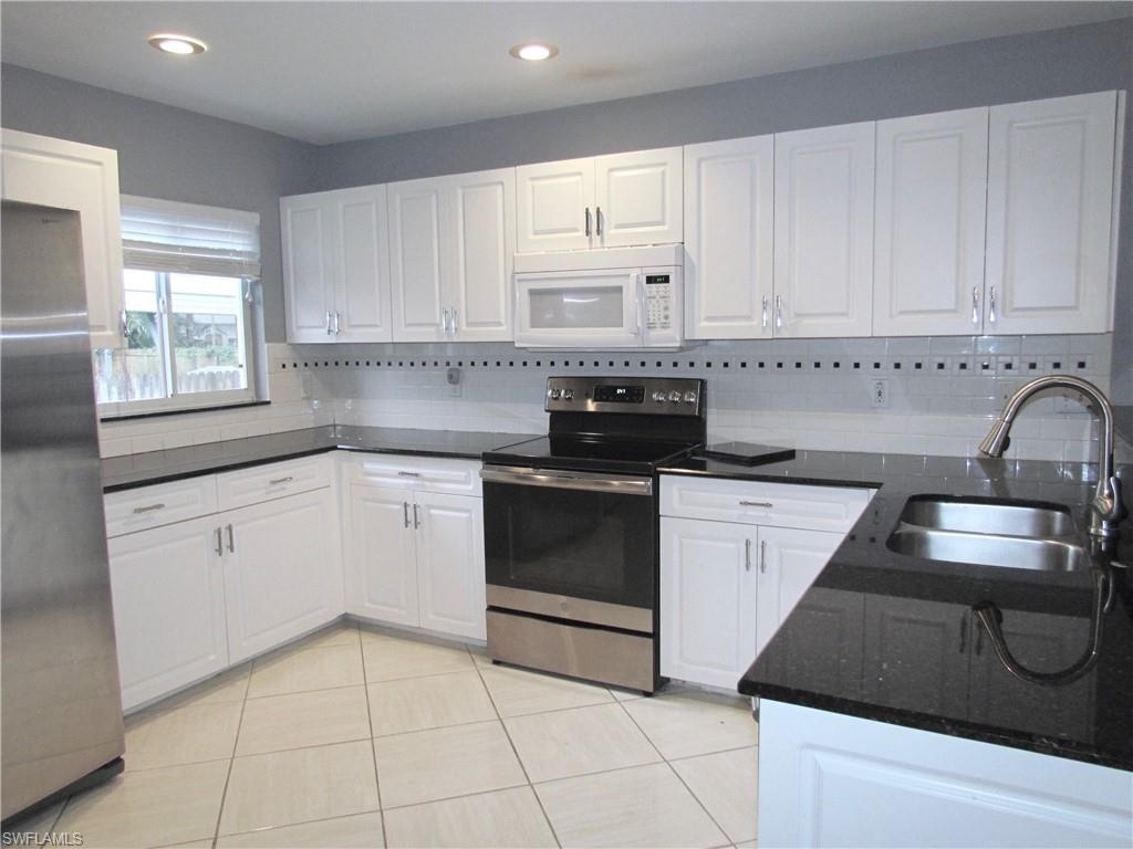 9124 Morris Road Fort Myers, FL 33967 - Photo 14 of 29 a kitchen with a stove sink and cabinets