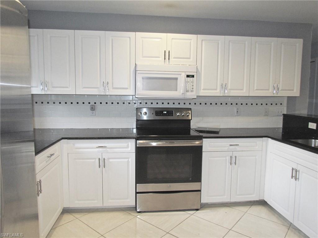 9124 Morris Road Fort Myers, FL 33967 - Photo 15 of 29 a kitchen with white cabinets and white appliances