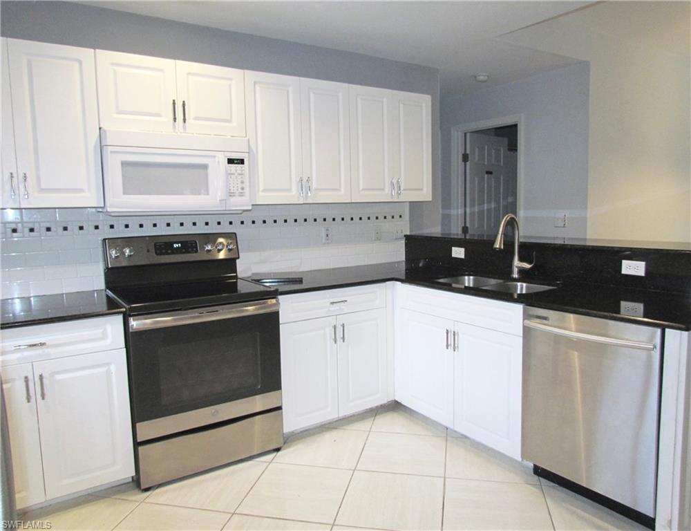9124 Morris Road Fort Myers, FL 33967 - Photo 16 of 29 a kitchen with white cabinets and black appliances